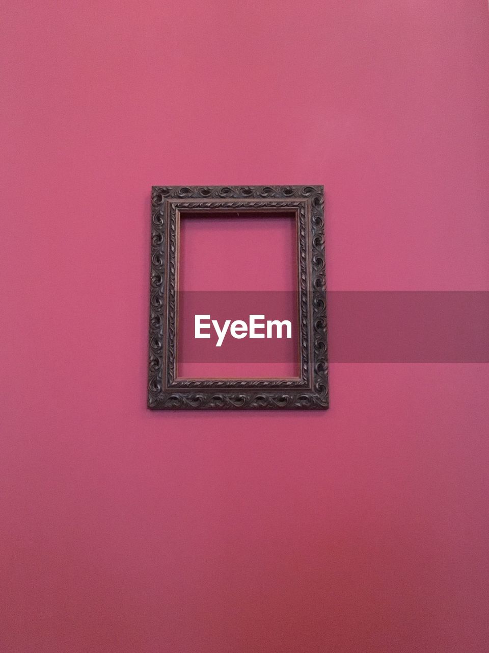 Picture frame hanging on pink wall