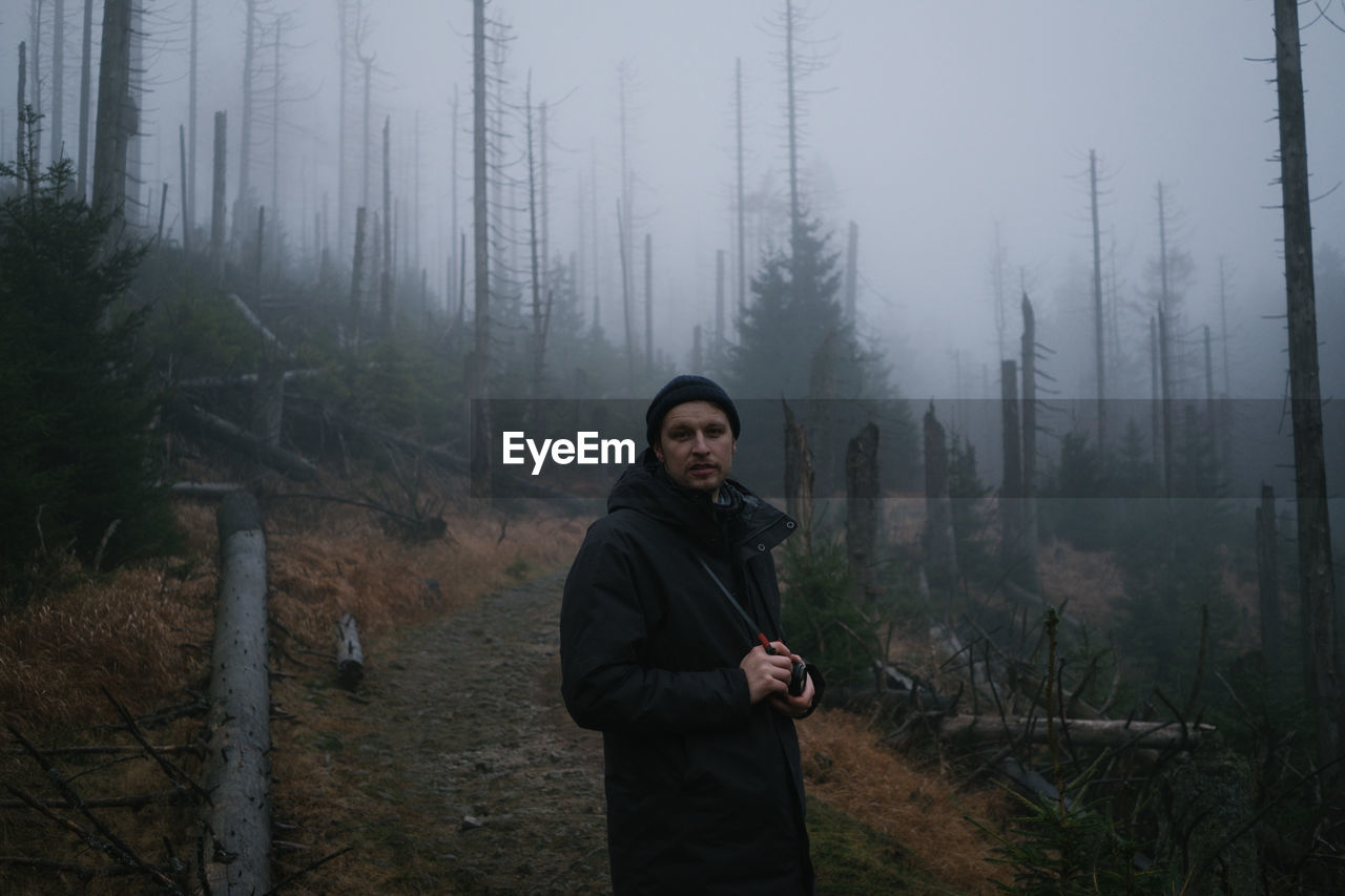 Full length of man standing in forest