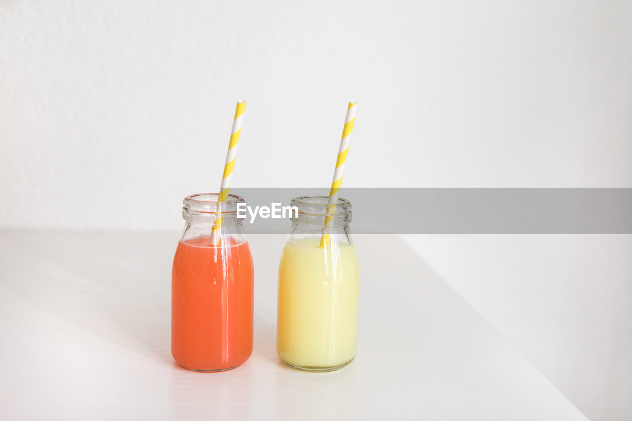 Close-up of drinks on table against white background