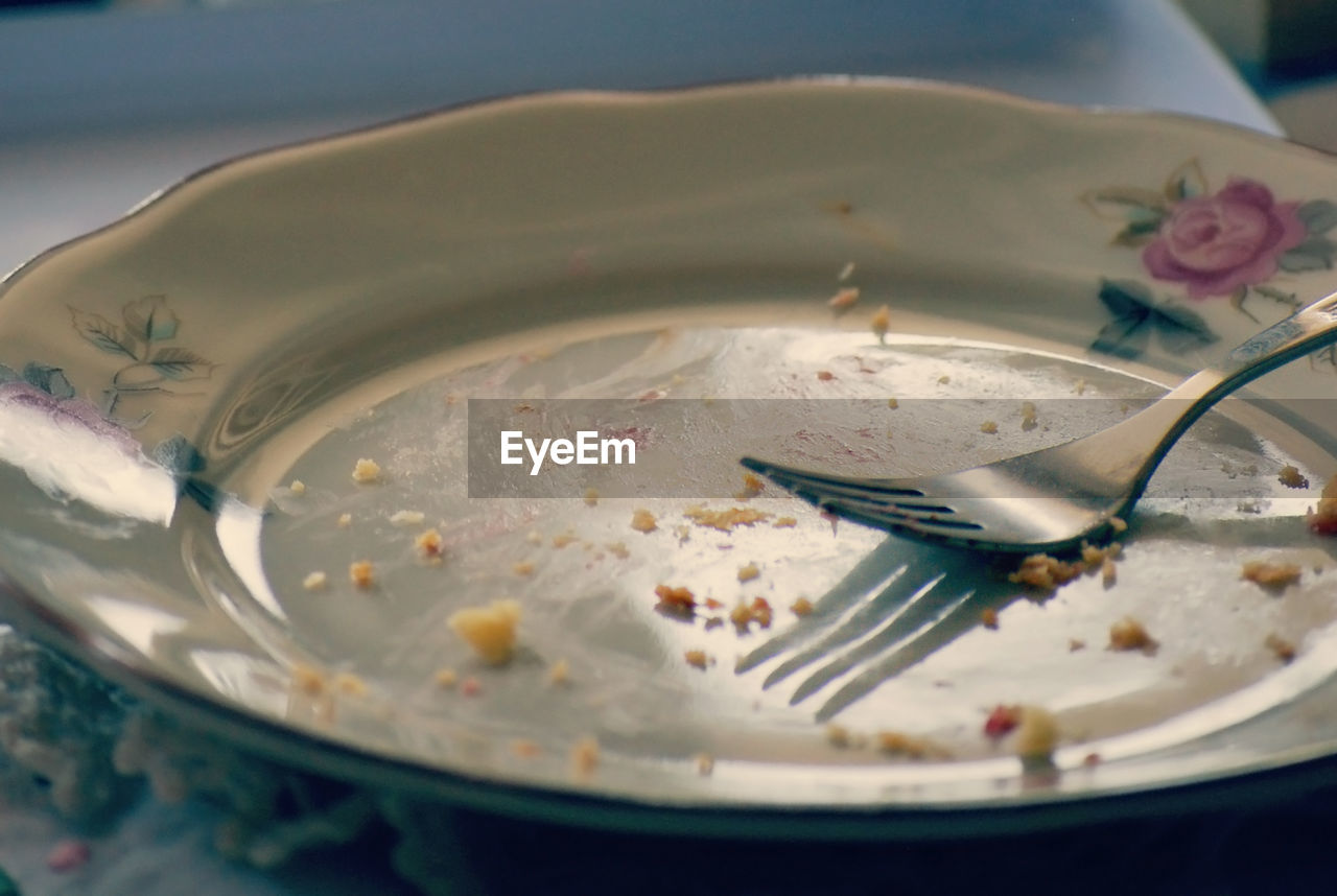 Close-up of empty plate with fork on table
