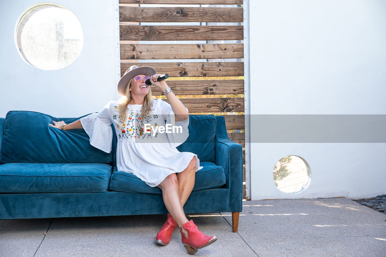 Woman singing karaoke on a blue couch in las vegas, nv