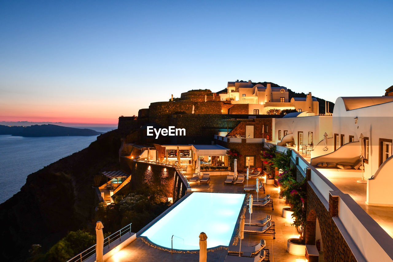 BUILDINGS BY SWIMMING POOL AGAINST SKY