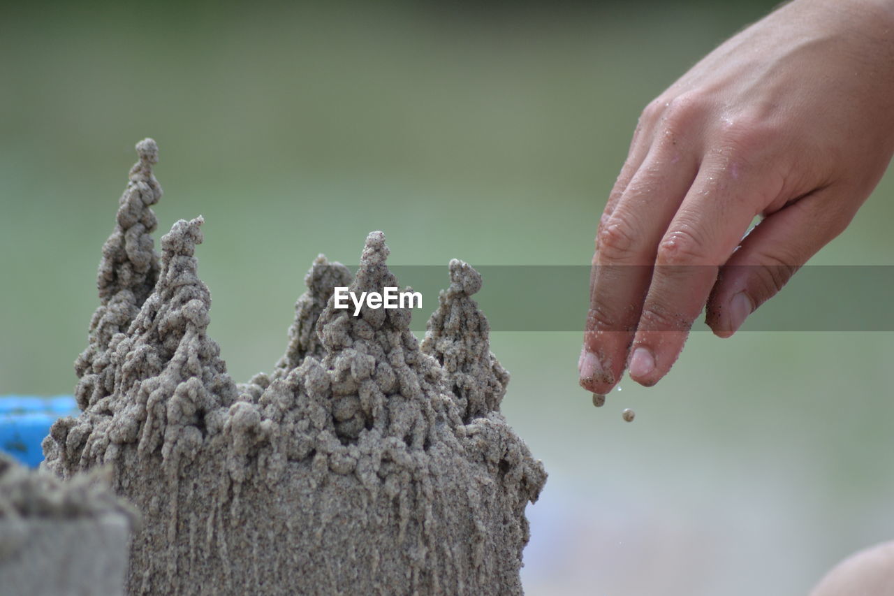 Cropped hand making sandcastle