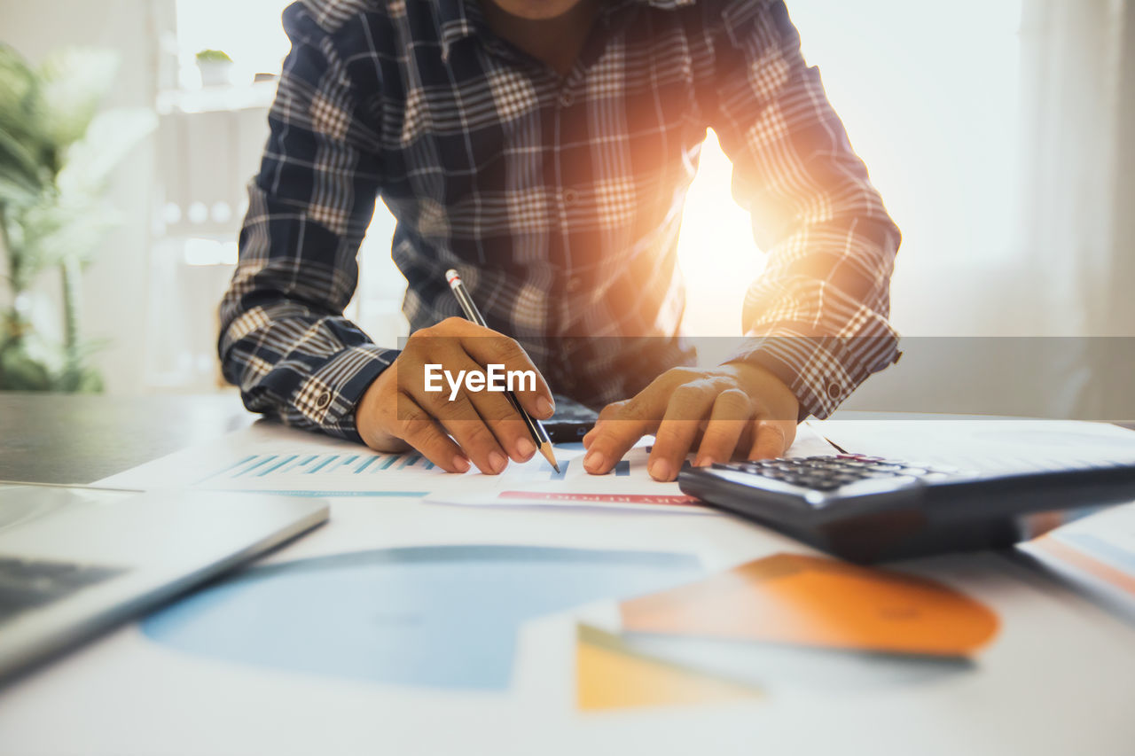 MAN WORKING ON TABLE IN OFFICE