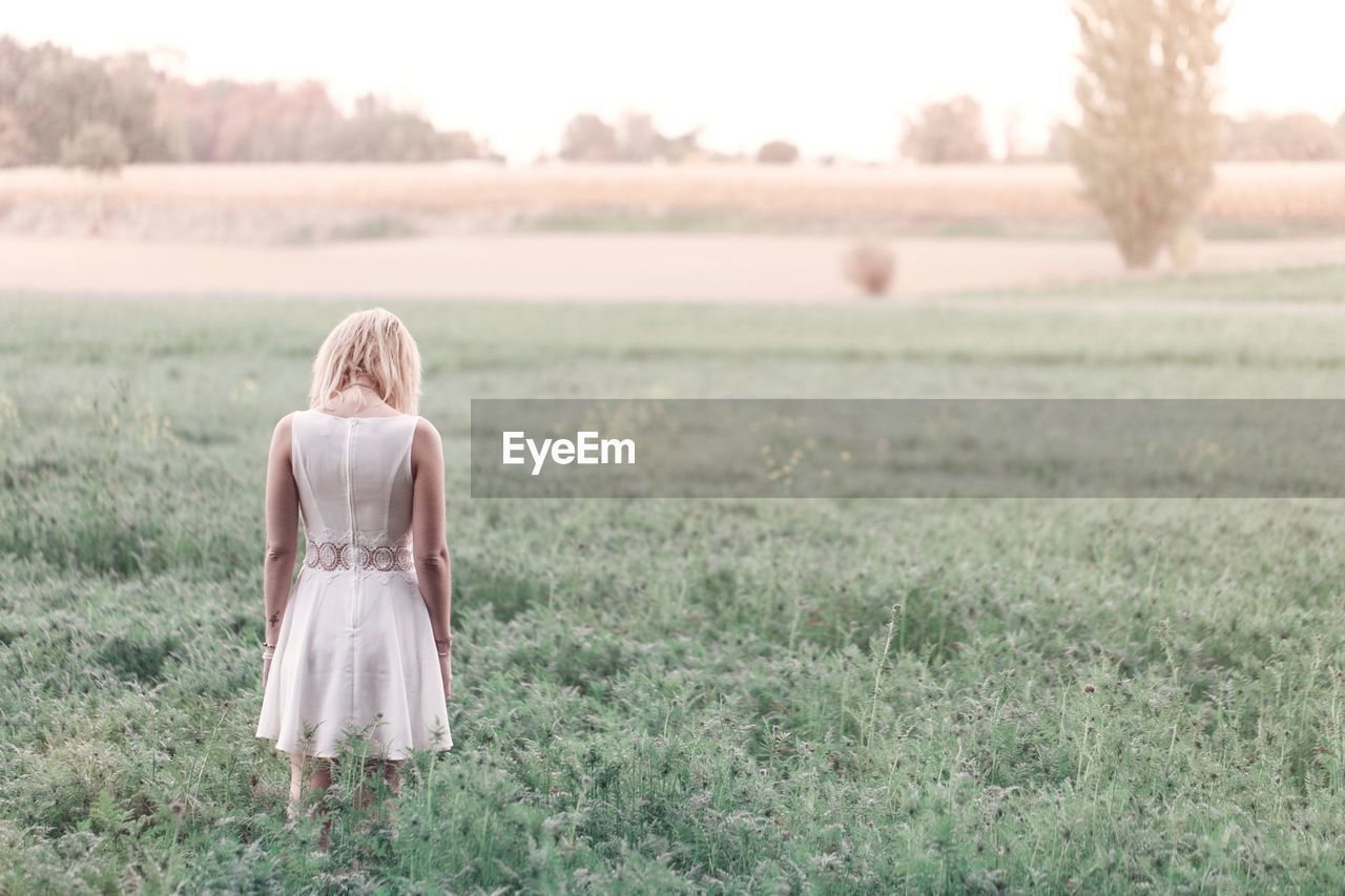 Rear view of woman standing on field