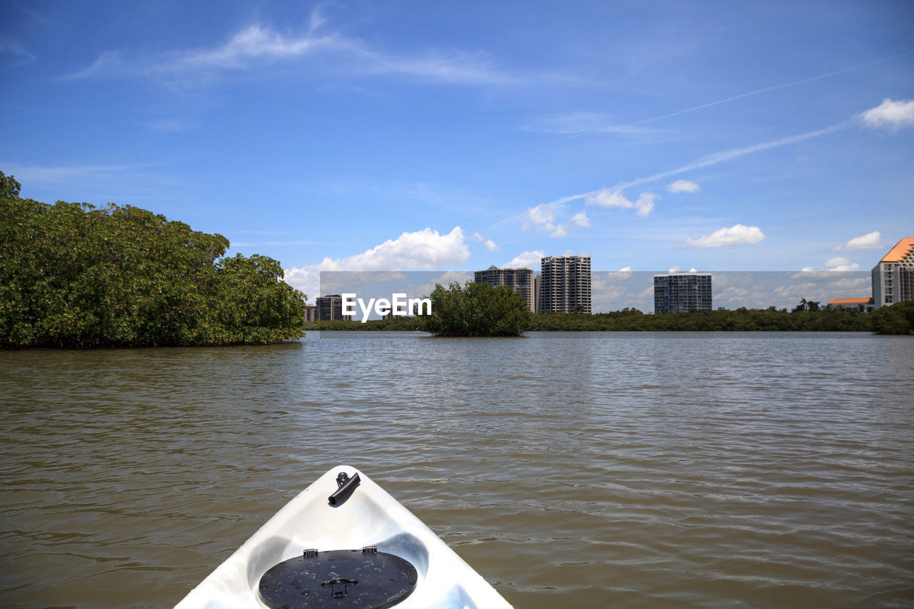 BOAT BY RIVER AGAINST SKY