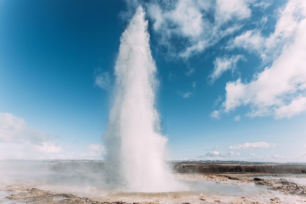 Geyser erupting against sky