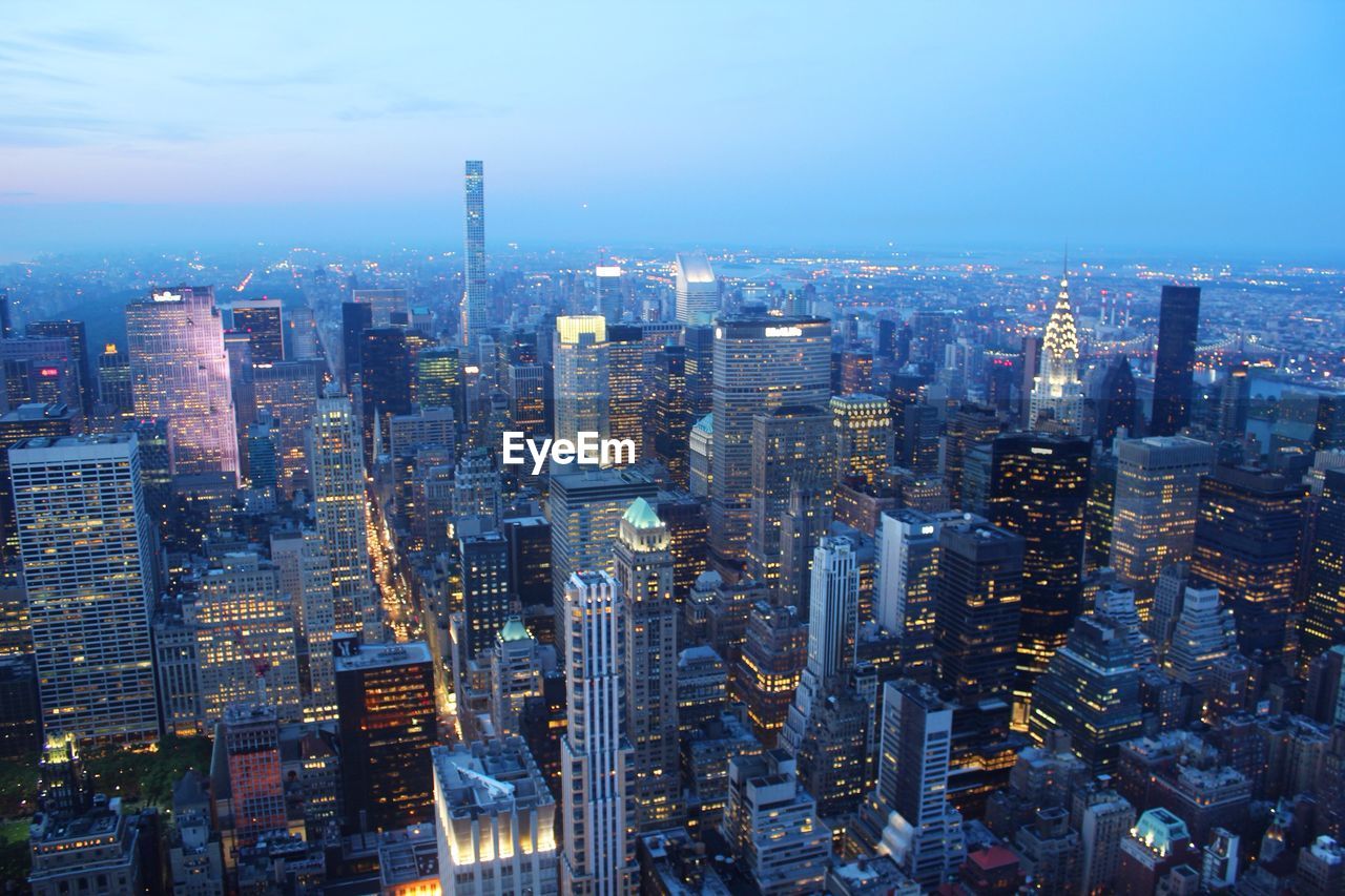 High angle view of chrysler building in illuminated city during sunset