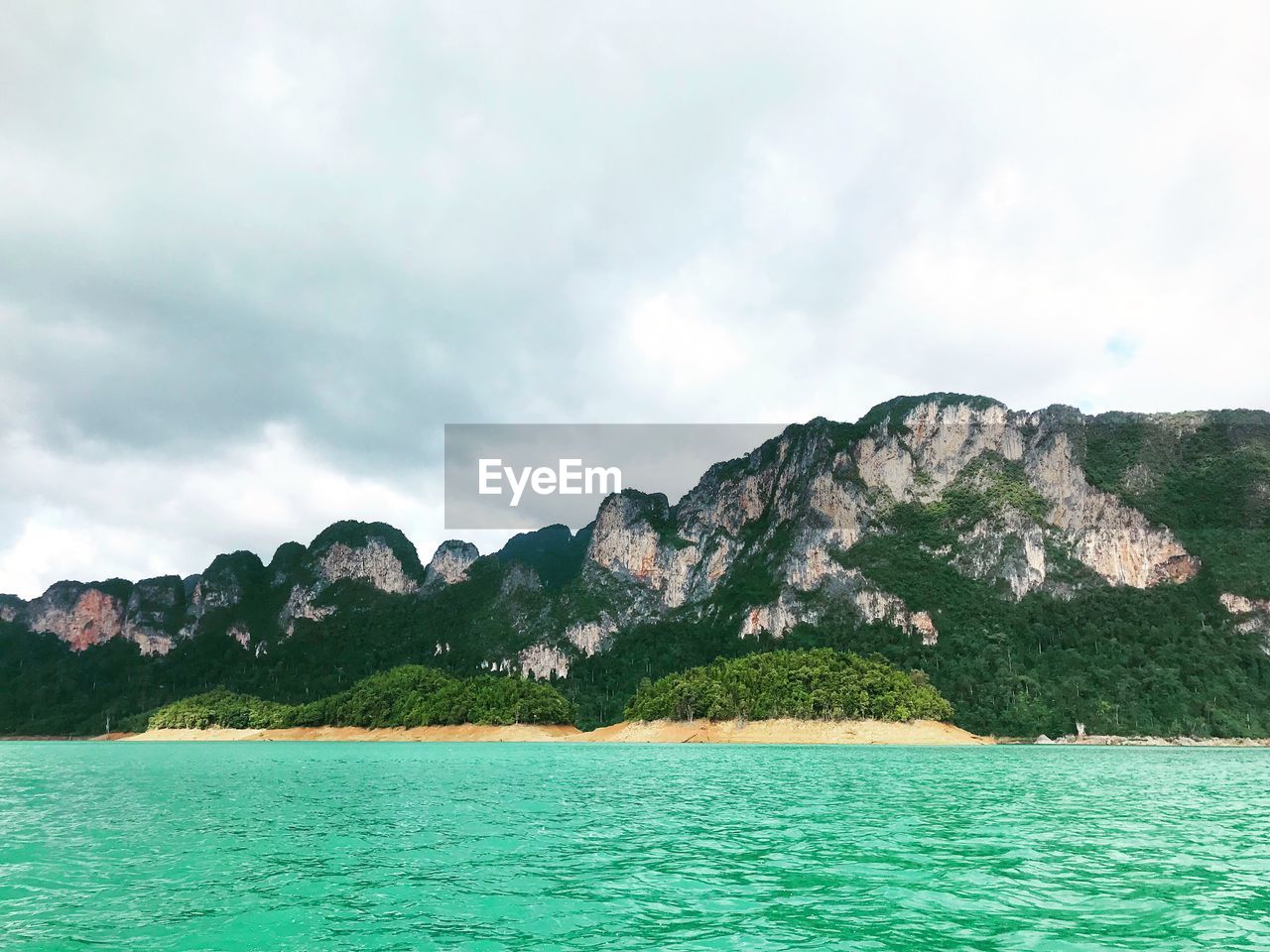 Scenic view of sea and mountains against sky