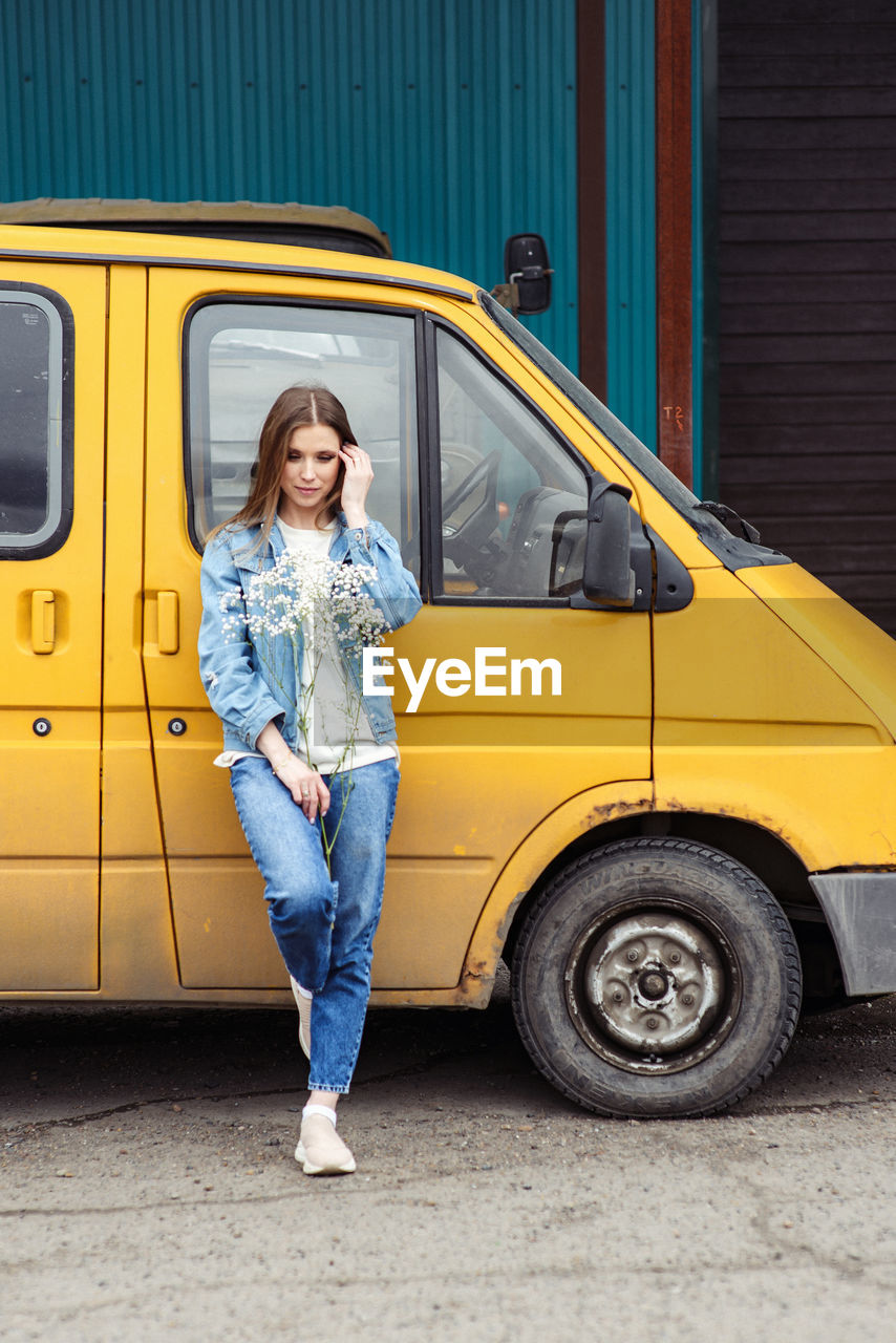 Full length of woman standing by car