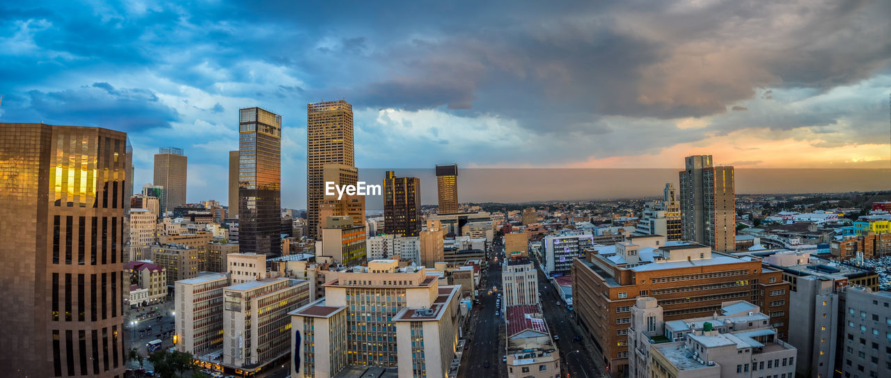 High angle view of buildings in city against cloudy sky