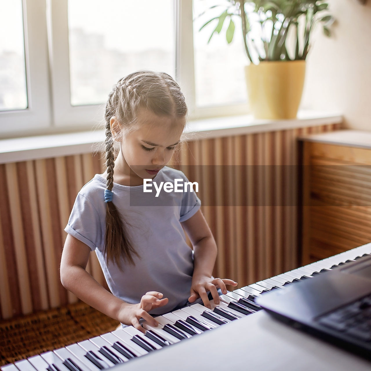 Cute girl playing piano at home