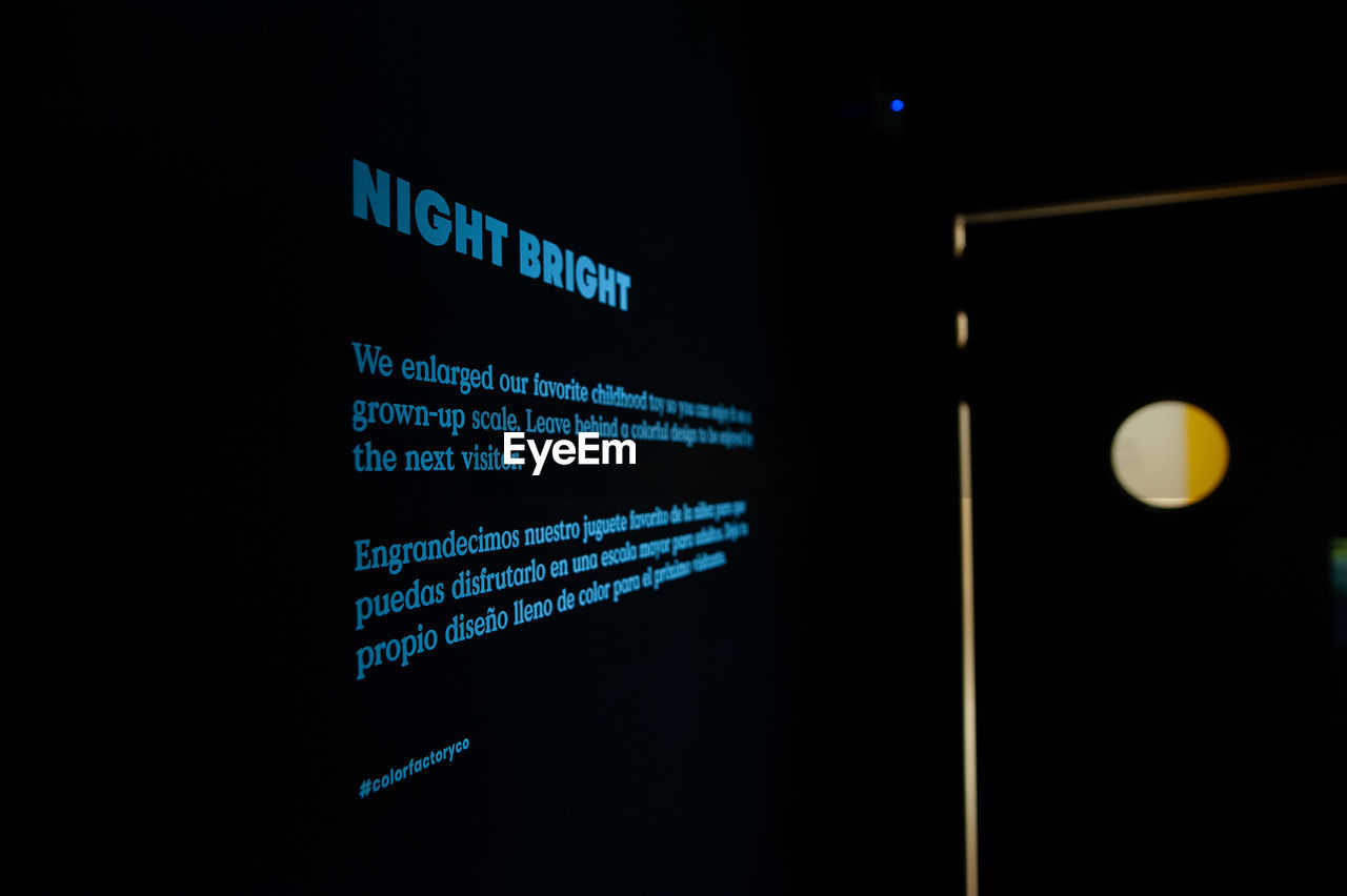 LOW ANGLE VIEW OF ILLUMINATED TEXT ON BLACK BACKGROUND