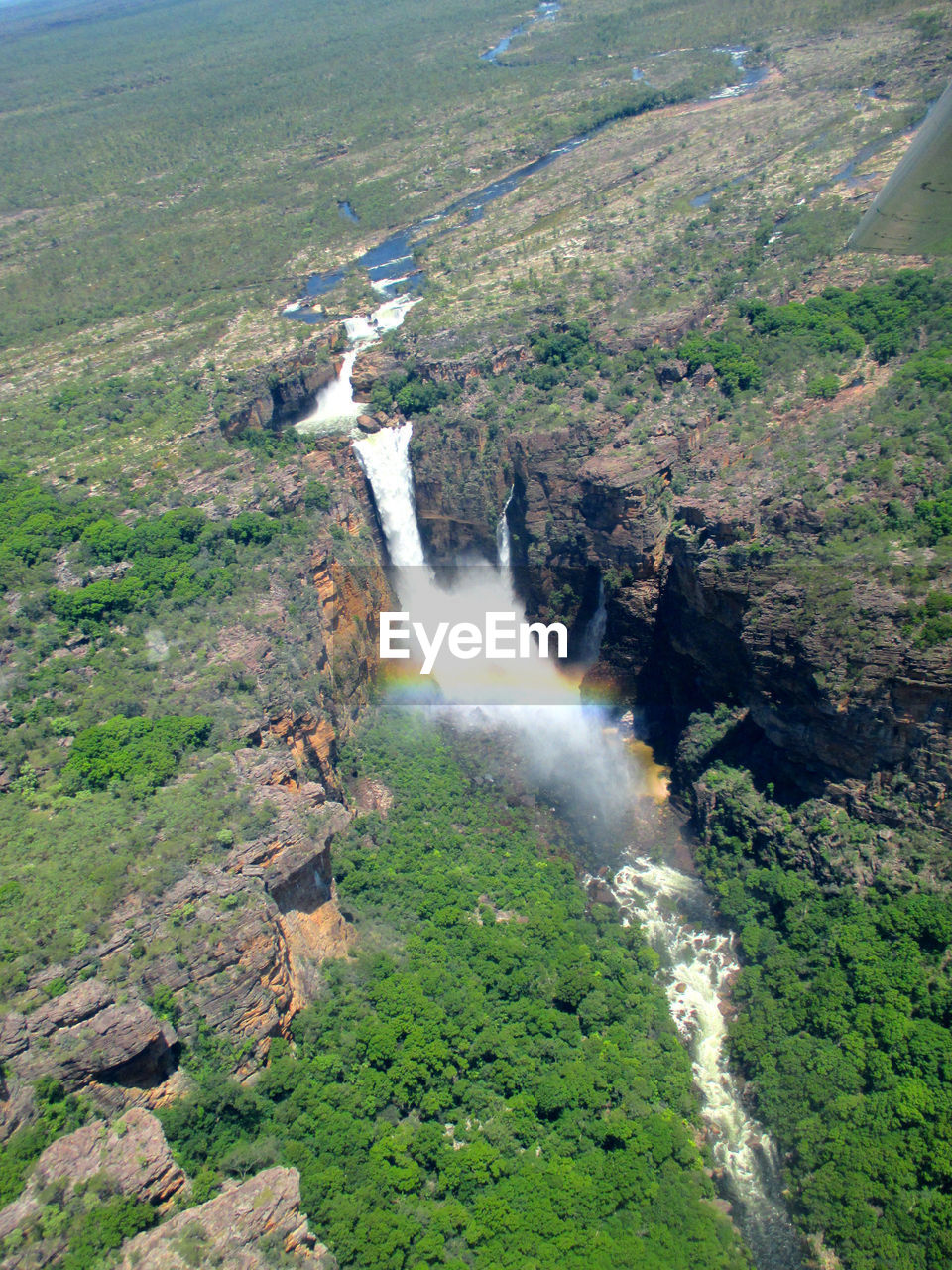 HIGH ANGLE VIEW OF WATERFALL AMIDST TREES