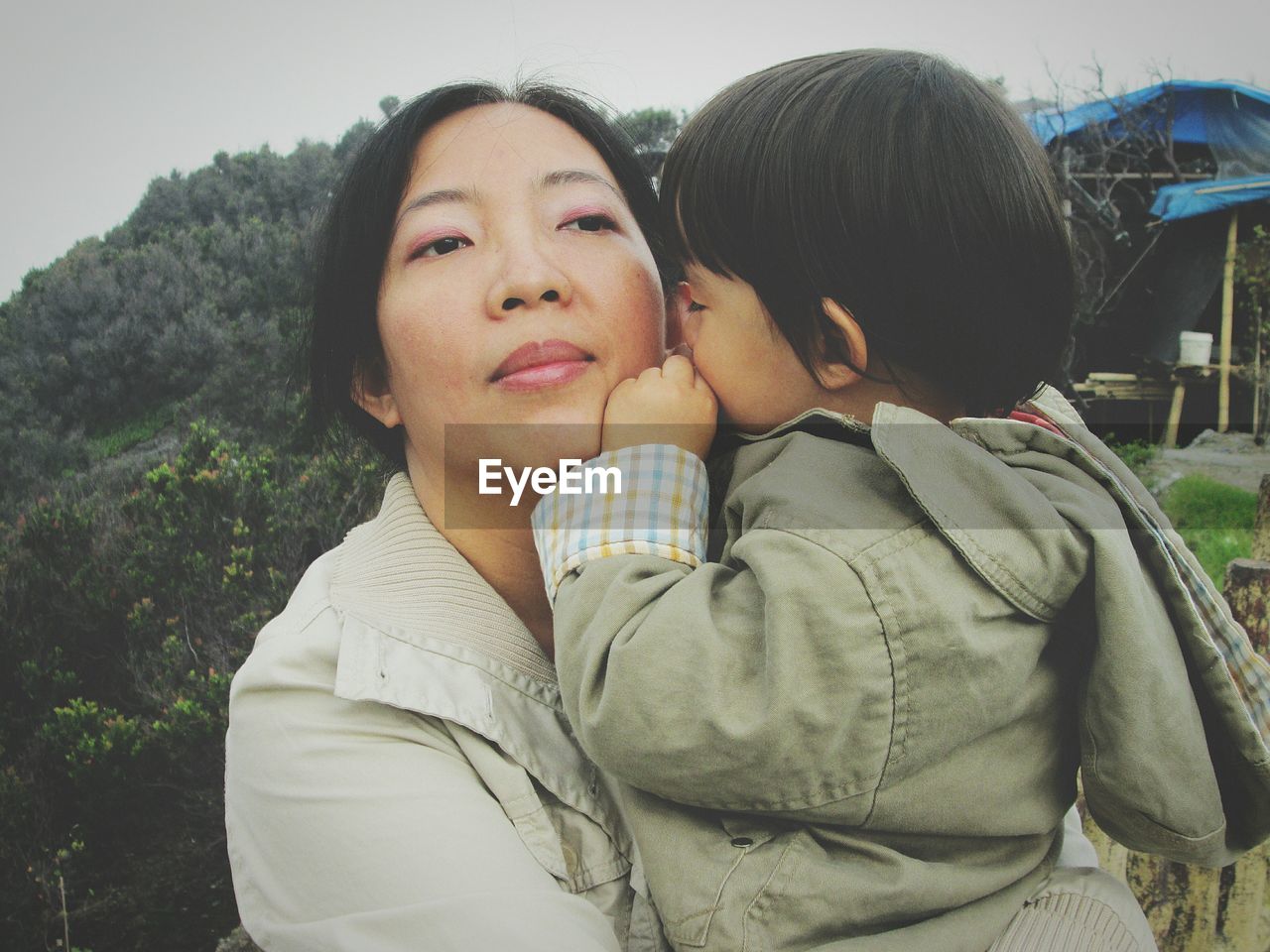 Close-up of mother holding son against mountain