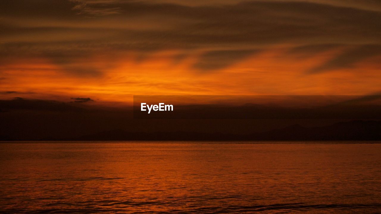 Scenic view of sea against orange sunset sky