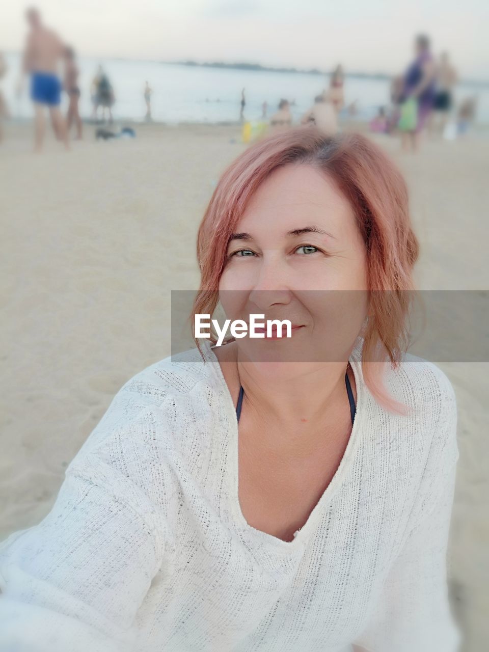 Portrait of smiling woman sitting at beach