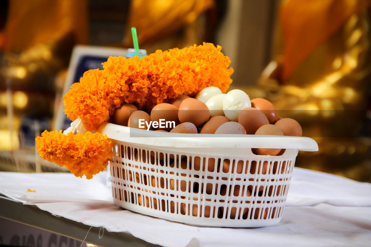 Eggs and marigold offering in basket