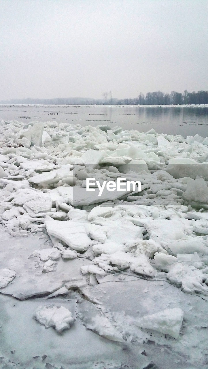 SCENIC VIEW OF FROZEN WATER AGAINST SKY