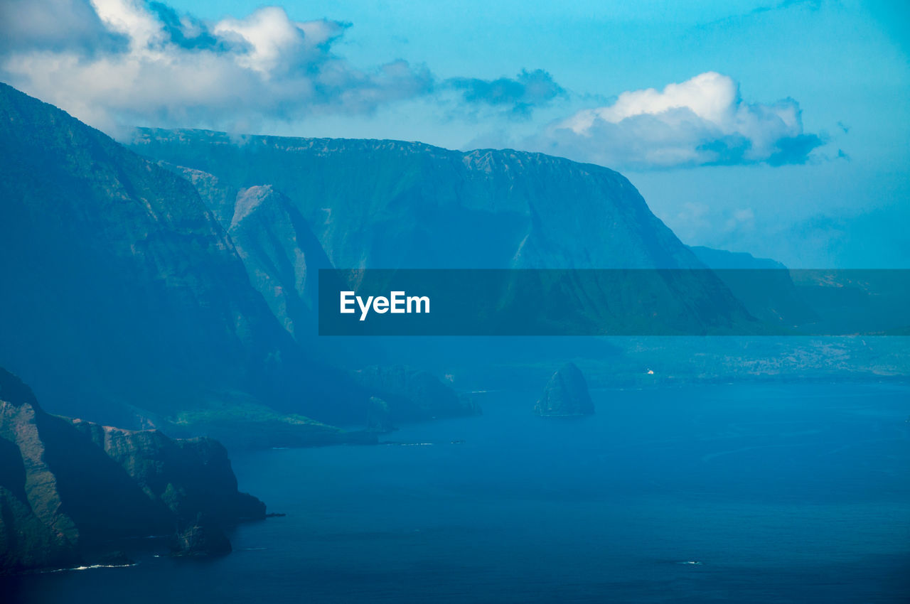 Scenic view of sea and mountains against sky