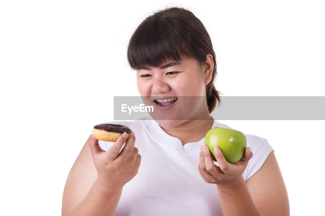 PORTRAIT OF SMILING WOMAN HOLDING APPLE