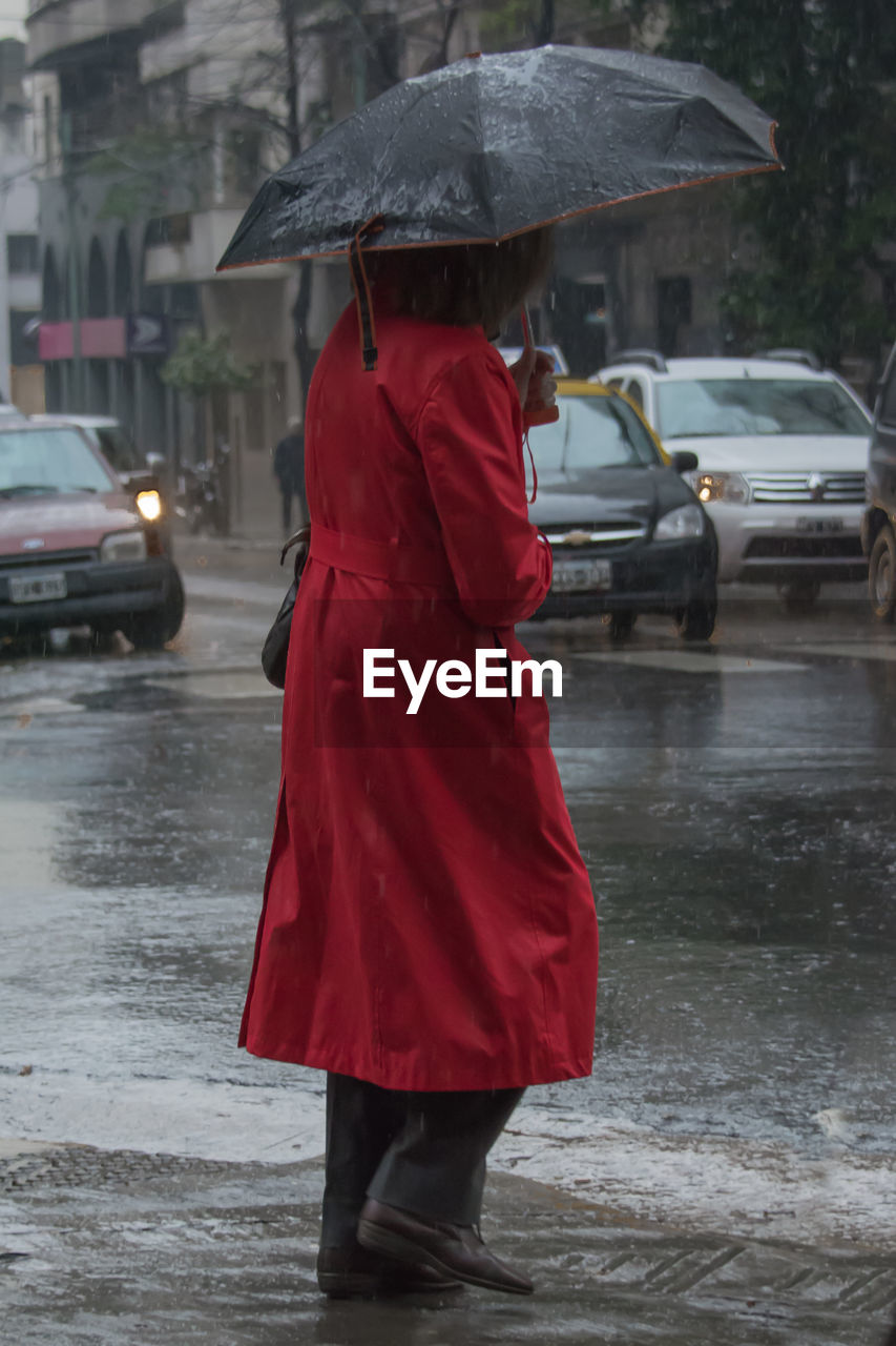 REAR VIEW OF PERSON WALKING ON STREET