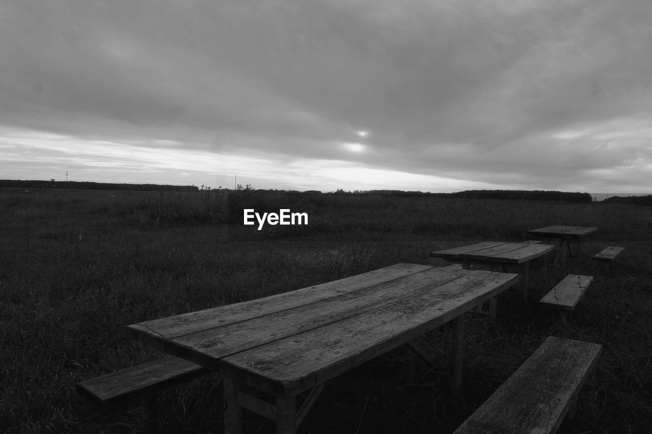 EMPTY ROAD BY FIELD AGAINST SKY