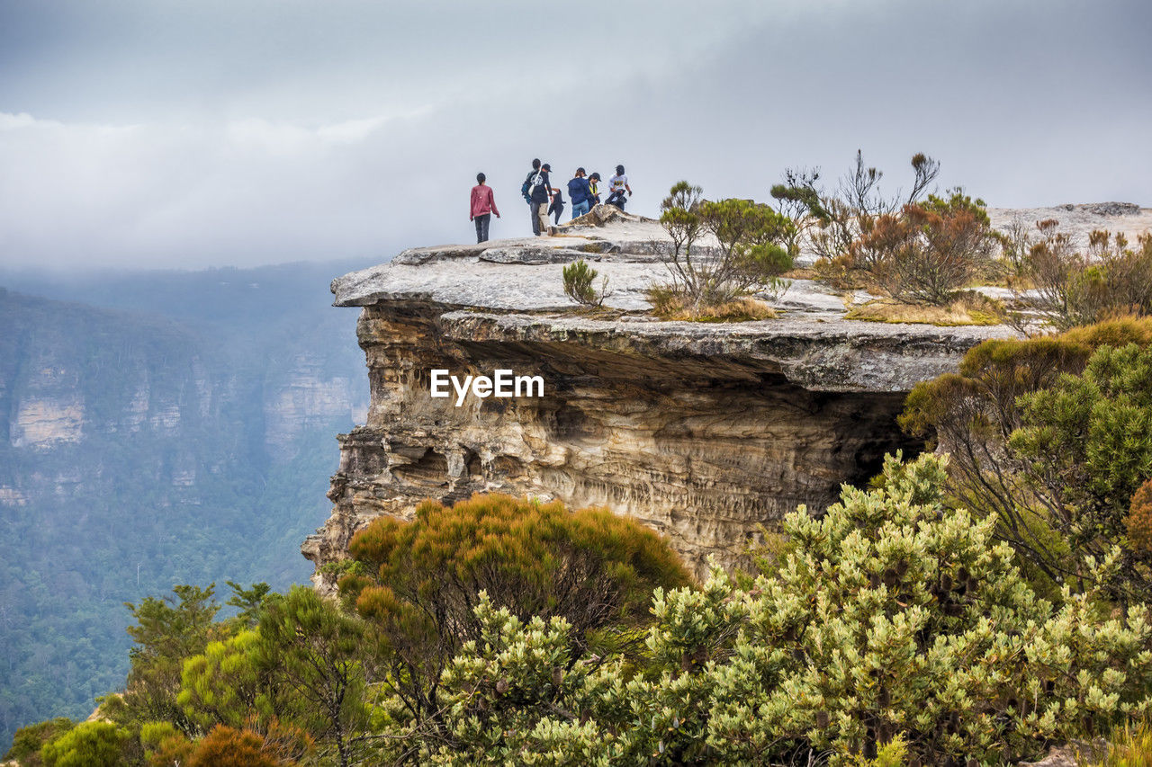 View of people standing on mountain against sky