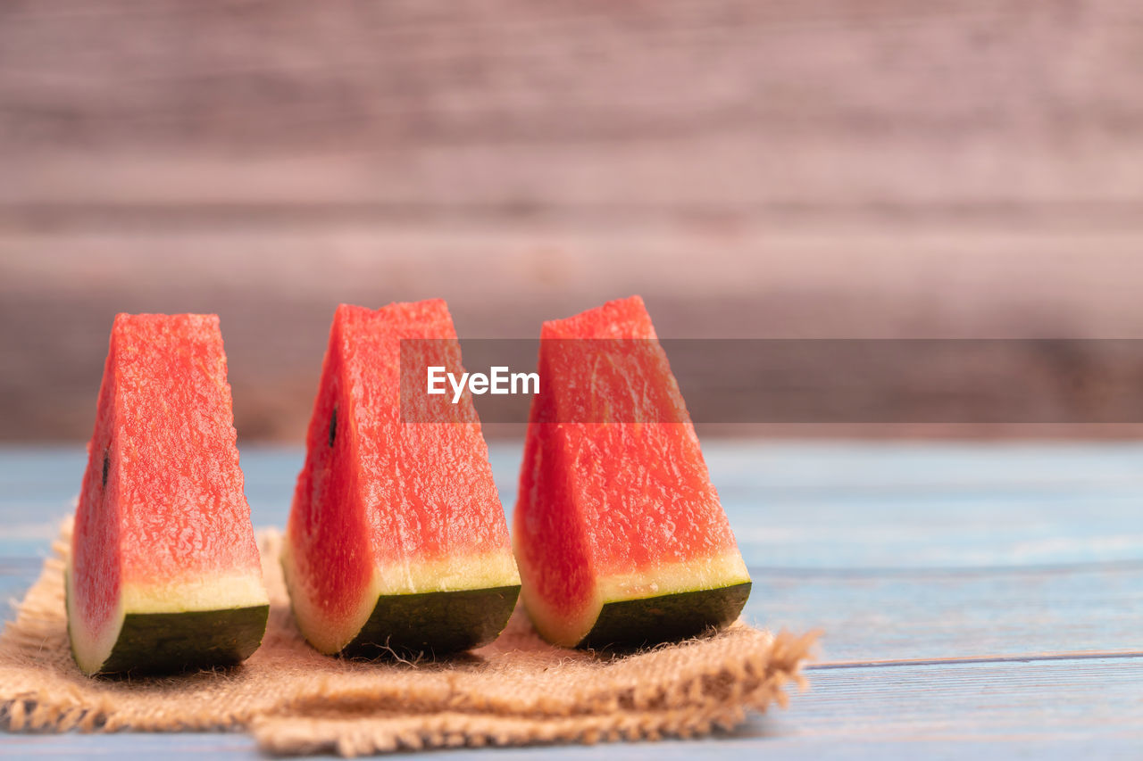 3 pieces of watermelon slices on the brown sack with blurred background
