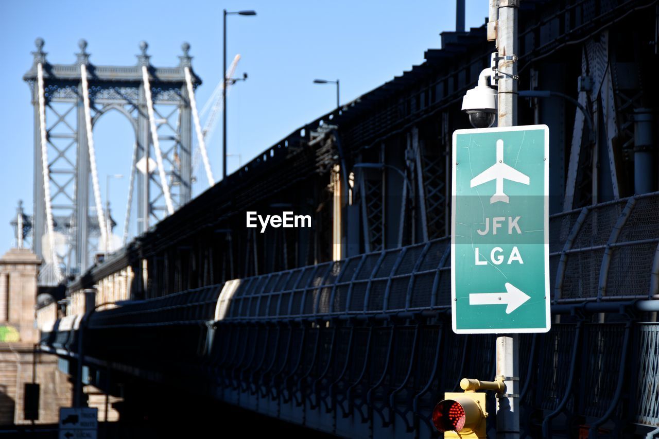 Information sign on bridge against sky in city