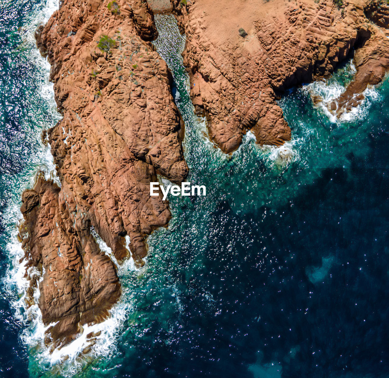 HIGH ANGLE VIEW OF ROCK FORMATIONS ON SEA SHORE