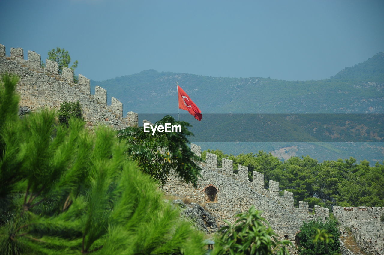 Red flag on mountain against sky