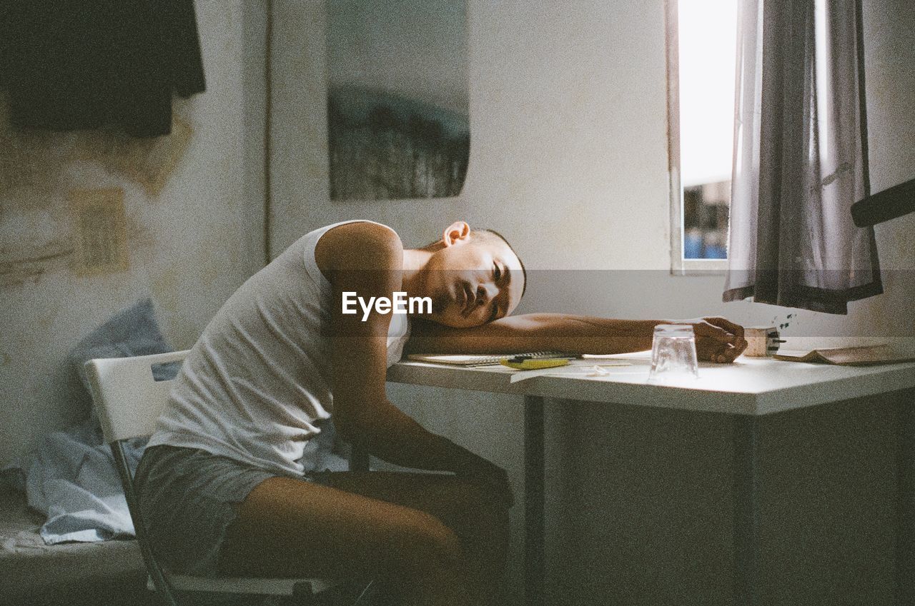 SIDE VIEW OF MAN SITTING AT TABLE