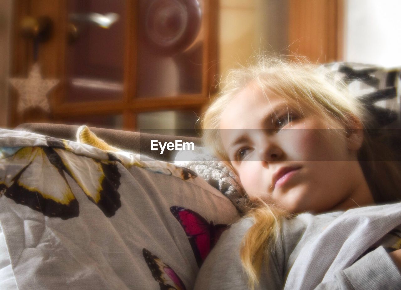 Close-up of woman relaxing on sofa at home