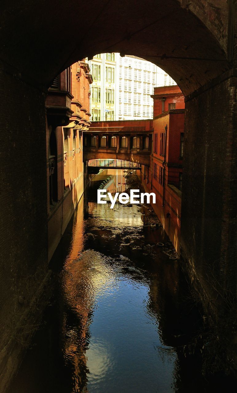 Bridge over canal by buildings