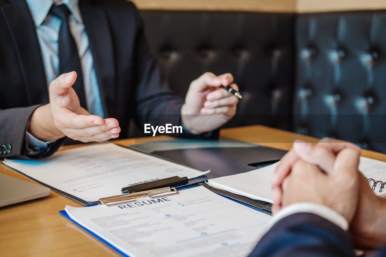 Cropped hands of businessman interviewing candidate in office