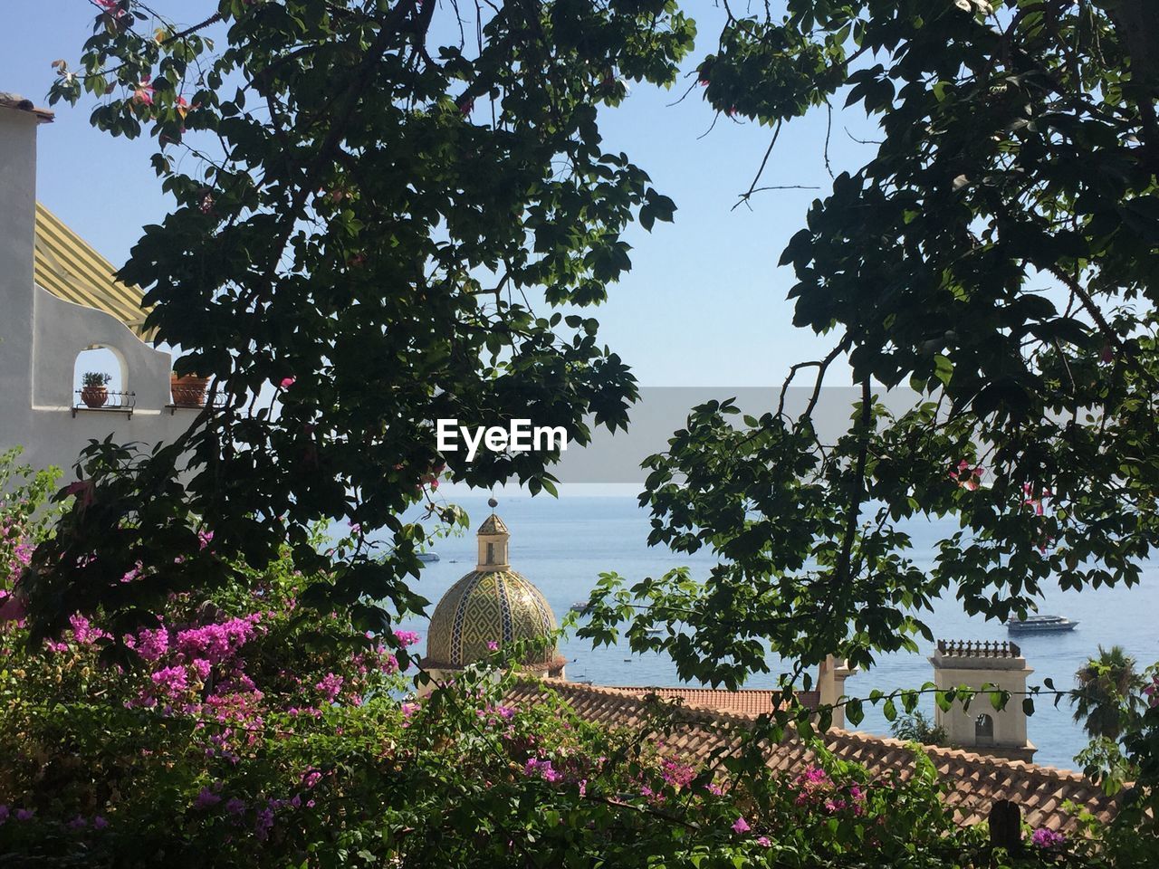 Scenic view of building next to sea against clear sky