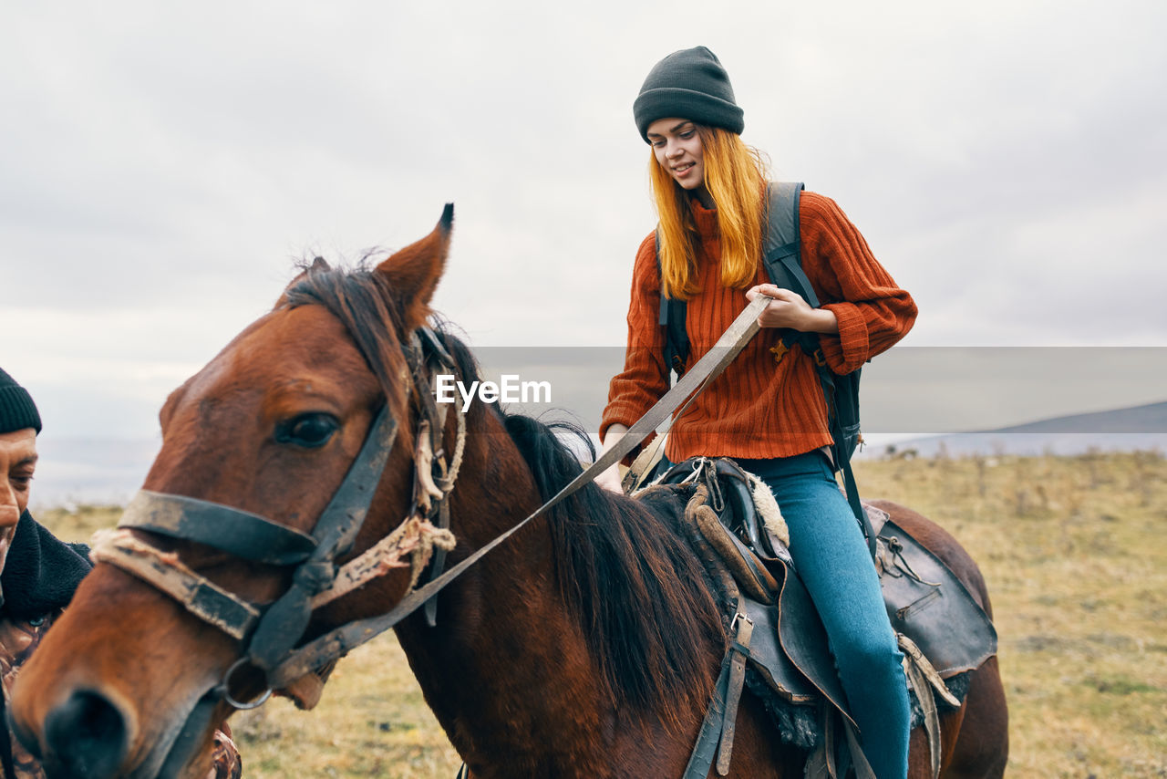 YOUNG WOMAN RIDING HORSE