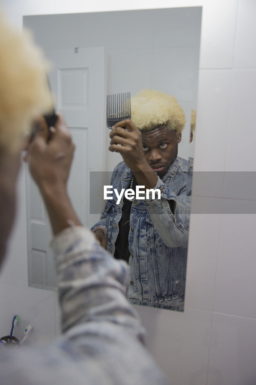 A young man getting ready in the mirror