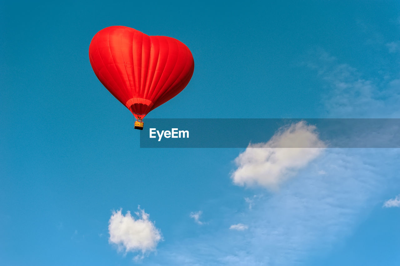 Low angle view of heart shape hot air balloon against blue sky