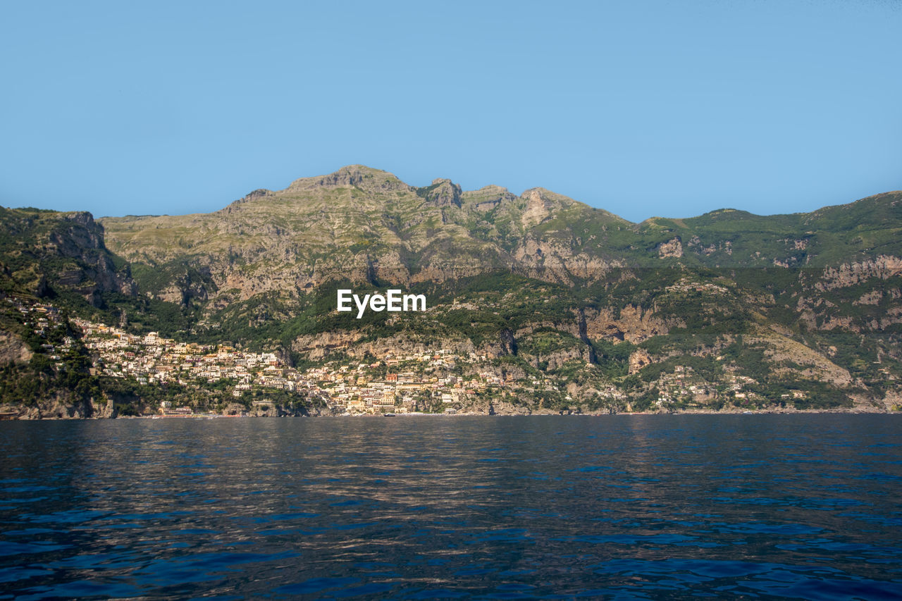 SCENIC VIEW OF MOUNTAINS AND SEA AGAINST CLEAR SKY