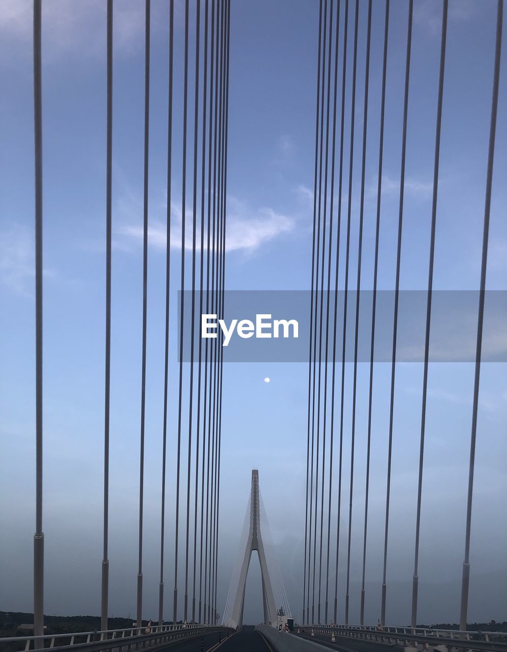 Low angle view of suspension bridge against cloudy sky