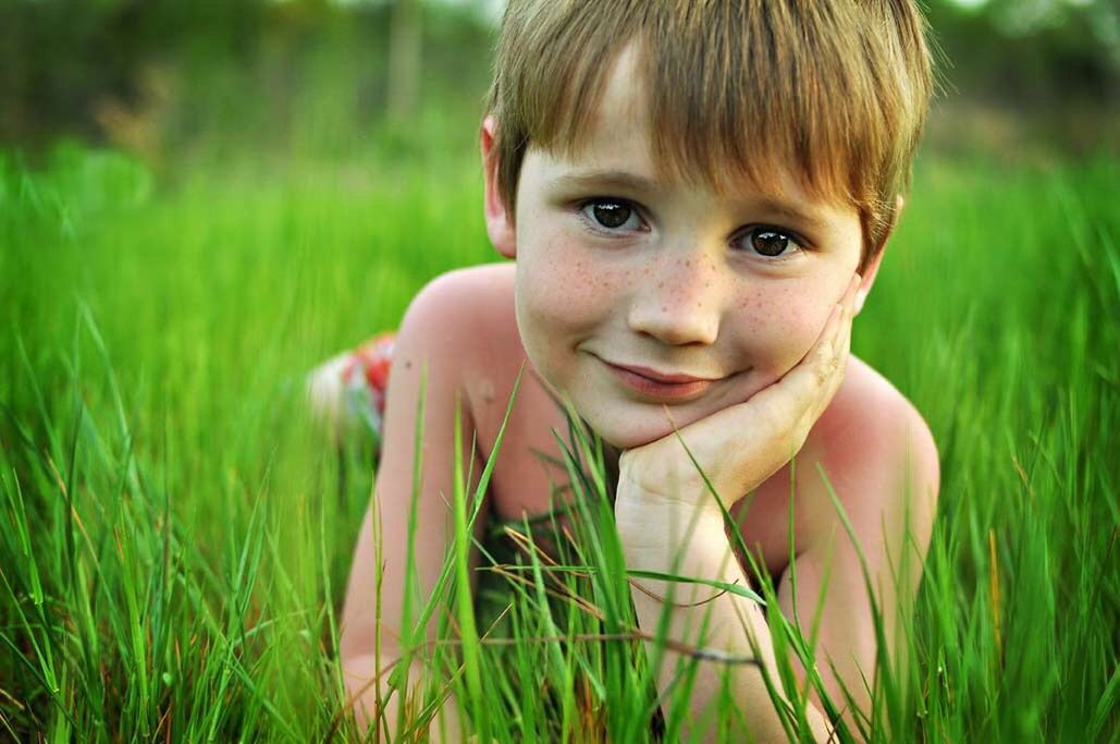 PORTRAIT OF GIRL ON GRASSY FIELD