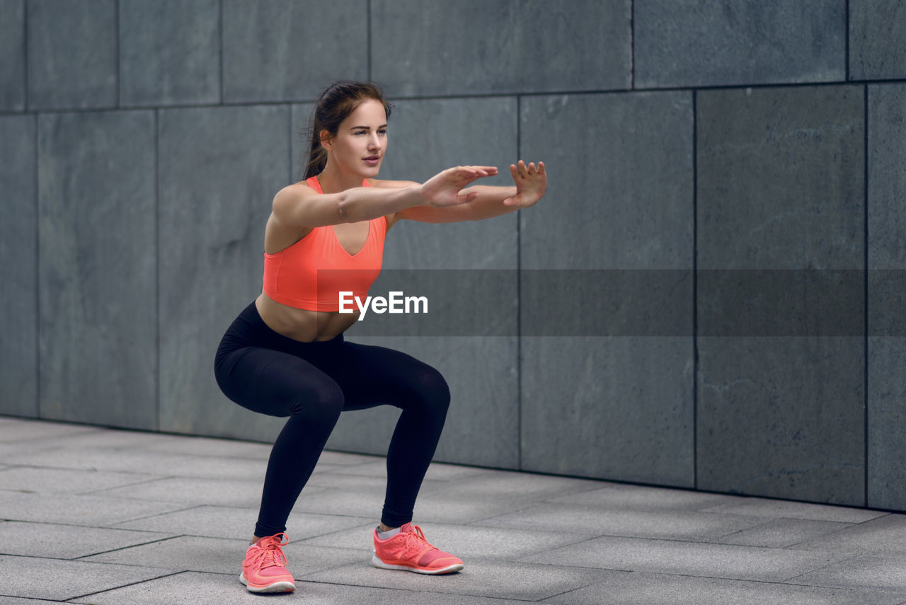 Woman in sports clothing doing squats