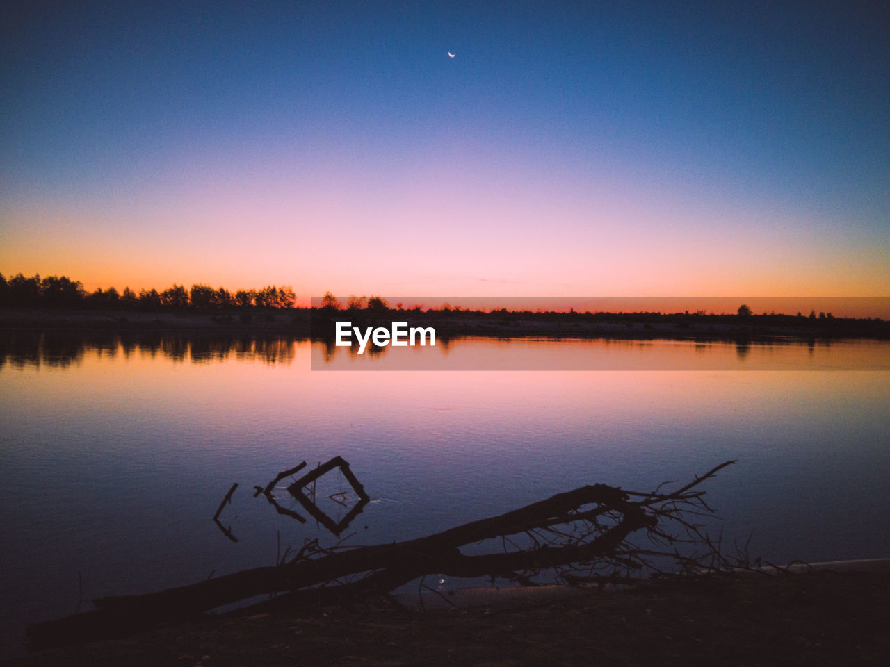 Scenic view of lake against sky during sunset