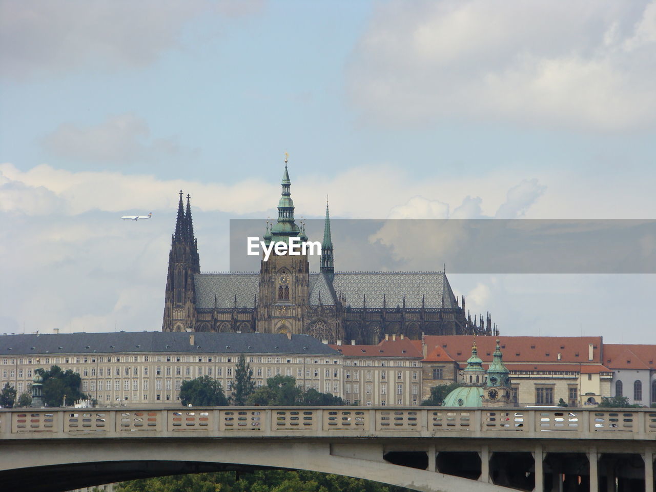 St vitus cathedral in prague against cloudy sky above the bridge