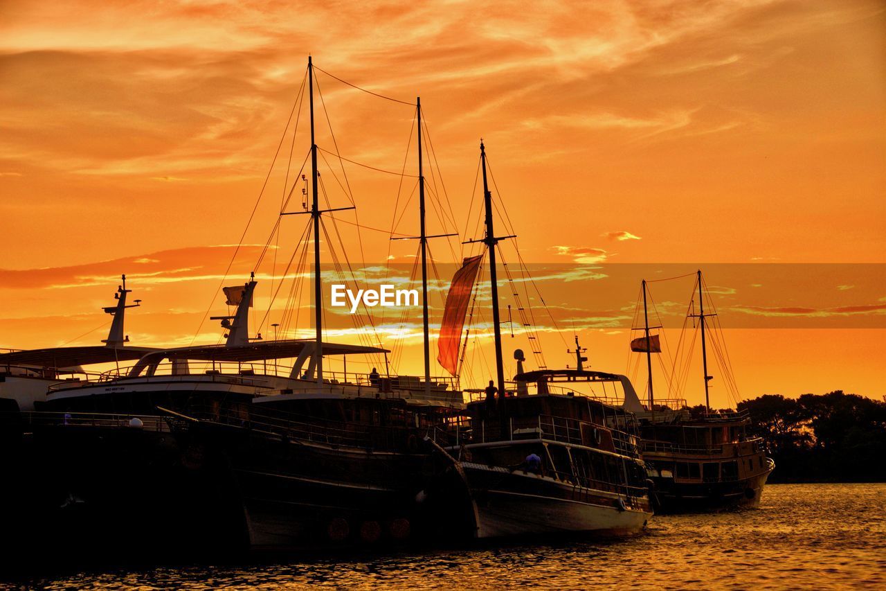 SAILBOATS MOORED AT HARBOR