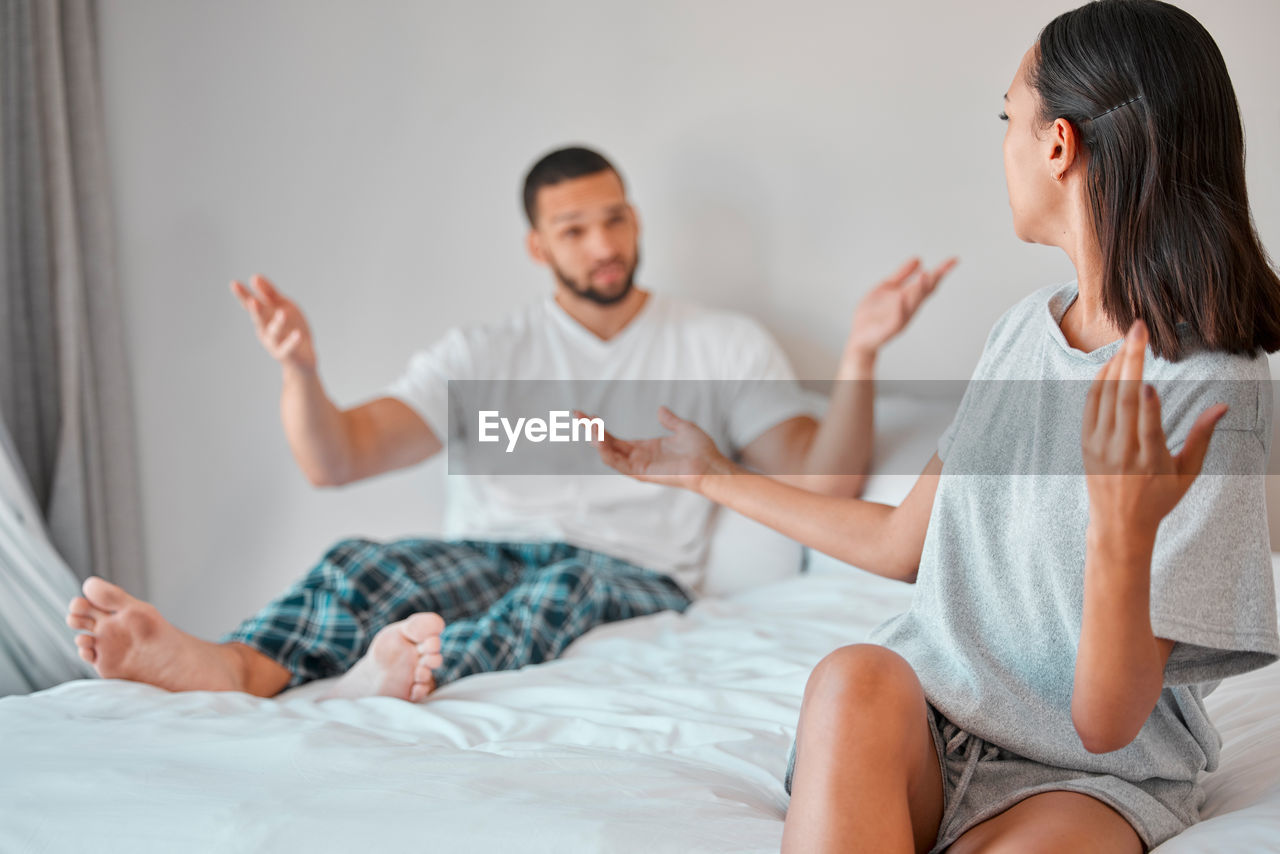 adult, domestic room, furniture, women, bed, two people, men, indoors, lifestyles, bedroom, female, relaxation, domestic life, togetherness, emotion, person, sitting, positive emotion, home interior, communication, young adult, happiness, clothing, casual clothing, love, smiling, bonding, lying down