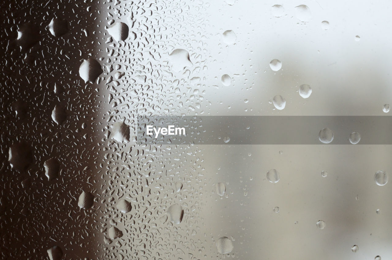 Window glass with water drops and blurred background