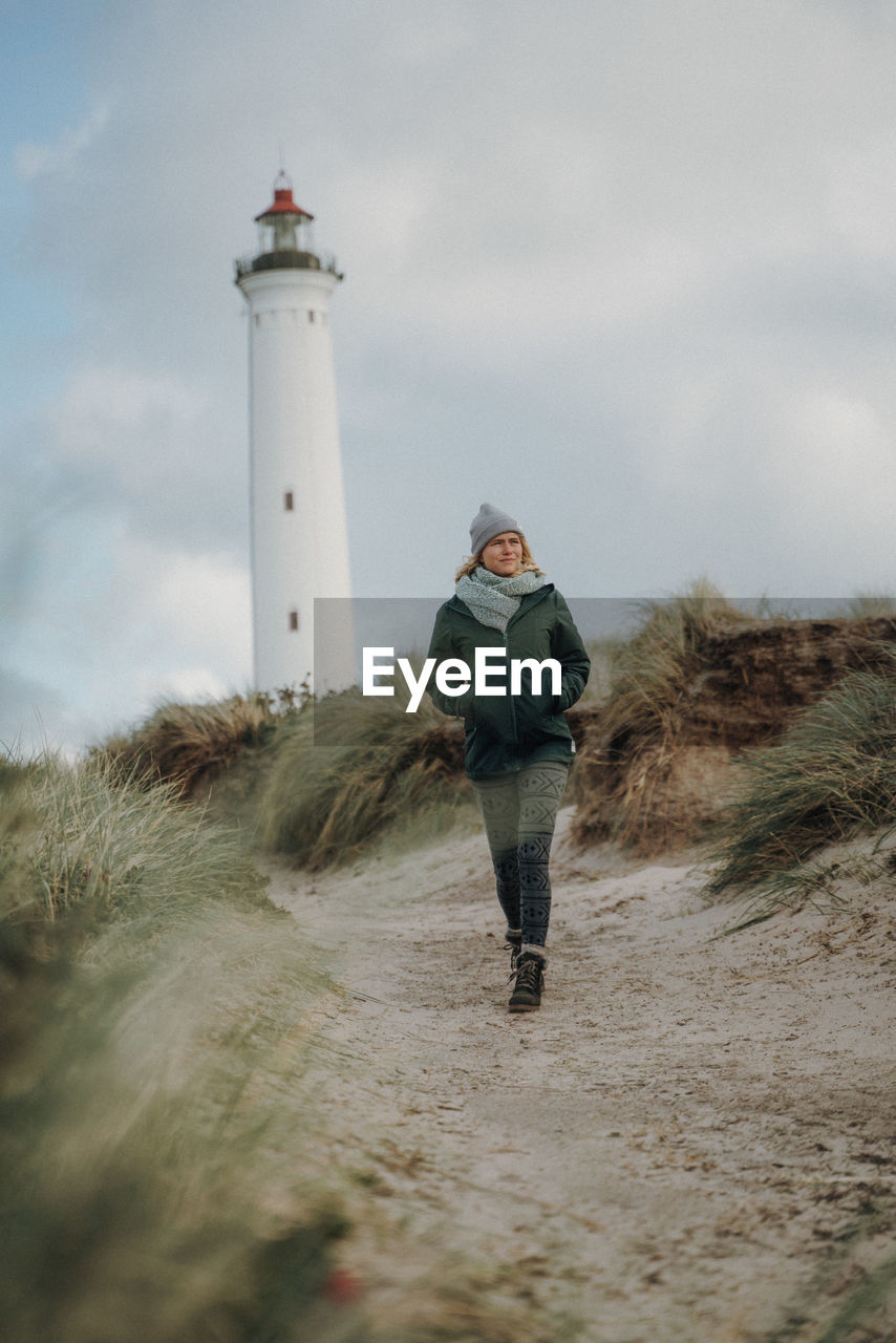 Woman walking against lighthouse during winter